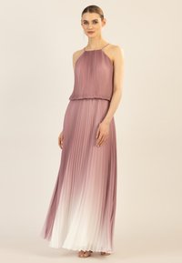 Robe maxi plissée dans des nuances de mauve à blanc, avec un col halter et une silhouette fluide. Tissu doux et léger.