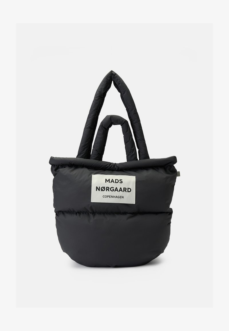 Black padded tote bag with two sets of handles and a white label reading "Mads Nørgaard Copenhagen" on front.