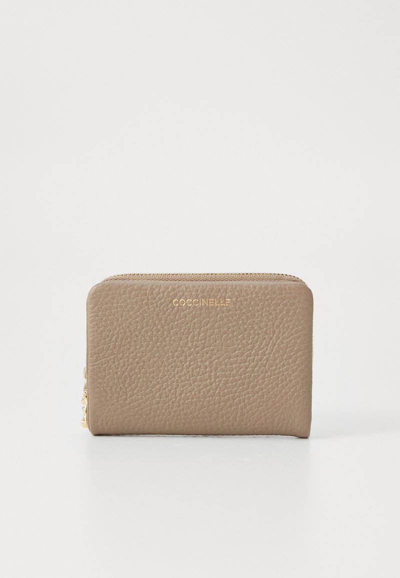 Beige leather wallet with a textured finish, gold hardware, and a zip closure. Features a brand name embossed on the front.