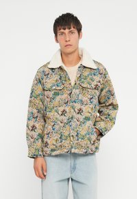 Floral-patterned jacket made of textured fabric, featuring a cream-colored faux shearling collar and two chest pockets.