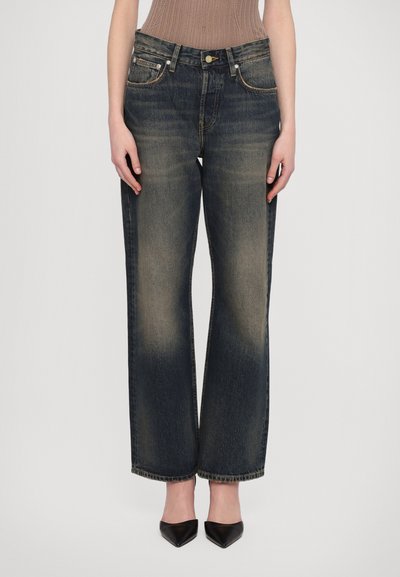 Jeans de pierna ancha azul oscuro con detalles de desgaste, cinco bolsillos y cierre de botón. Fabricados en tela de mezclilla, con un corte recto.
