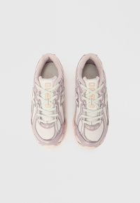 Pantofi sport din plasă roz deschis și crem, cu suprafață texturată, sistem de șireturi și talpă de cauciuc. Prezintă accente reflectorizante și vârf rotunjit.