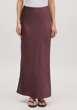 Maxi rok in diep bordeauxrood, gladde textuur, aansluitende taille, enkel-lang, gecombineerd met zwarte slippers voor een casual look.