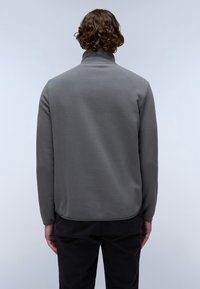 Sudadera de felpa gris con cuello alto, textura suave, corte recto y acabado limpio en el dobladillo. Presenta mangas largas y un ajuste holgado.