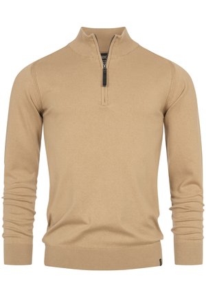 Suéter beige con cuello con cremallera y mangas largas, hecho de una tela suave, que presenta puños y dobladillo acanalados, y una pequeña etiqueta de logo en la parte inferior.