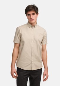 Korte mouw beige overhemd van katoen, met een button-down kraag, knopen aan de voorkant en een klein logo geborduurd op de borst.