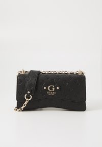 Borsa a tracolla in finta pelle nera con texture, motivi in rilievo, hardware dorato, tracolla a catena e placca con logo sul davanti.