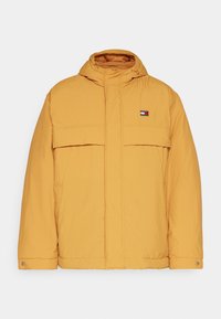 Gul puffjacka med huva, med dragkedjestängning, två framfickor och en logotypapplikation på den övre vänstra bröstfickan. Slät textur.