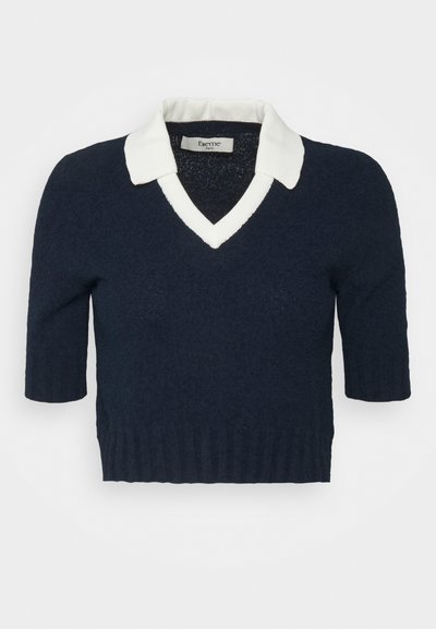 Sweater azul-marinho de manga curta com um colarinho em V branco e bainha canelada, apresentando um tecido de malha texturizada. A etiqueta diz "Eierme, Paris."