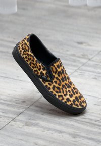 Cipele slip-on s otisakom leoparda s crnim akcentima, izrađene od tkanine s teksturiranom površinom, s okruglim vrhom i gumiranim đonom.