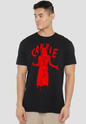 Schwarzes Baumwoll-T-Shirt mit einer Grafik einer Figur in einem roten Kleid, darüber steht das Wort "CARRIE" in abgenutzten roten Buchstaben.