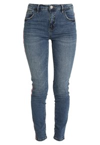 Blå denimjeans med skinny fit, med röda och vita ränder längs sidsömmarna och en klassisk knapp- och dragkedjestängning.