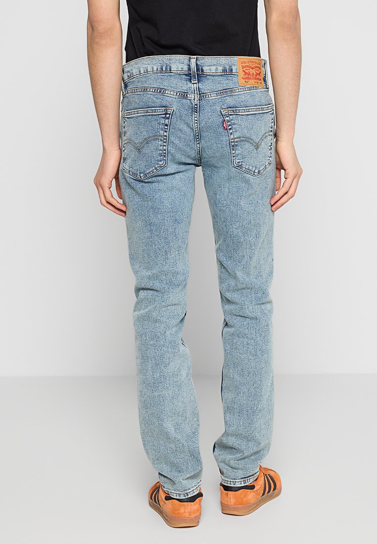 Jeans de mezclilla de color azul claro con corte recto, que cuentan con bolsillos traseros clásicos y una etiqueta de marca Levi's en la pretina.