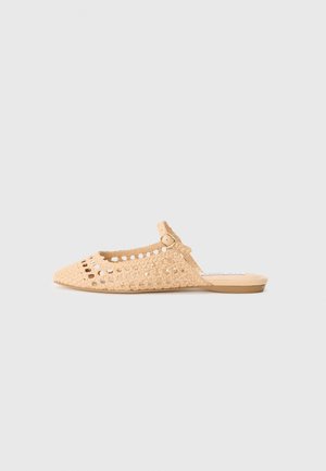 Mule tissée beige à bout pointu, motif ajouré, petite bride à boucle et semelle plate sur fond clair uni.