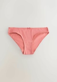 Sous-vêtement féminin style bikini en coton rose avec un petit nœud centré sur la taille, sur fond uni.