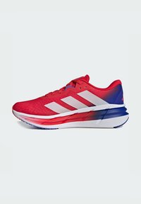 Rote Sportlichkeitsschuhe mit einem strukturierten Mesh-Obermaterial, weißem Drei-Streifen-Design, farbverlaufender Ferse von Rot nach Blau und einer mehrfarbigen Sohle.