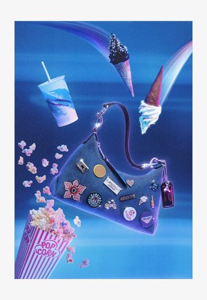 Borsa in denim con spille galleggia tra popcorn, una tazza di soda e tre coni di gelato su uno sfondo blu con strisce di luce.