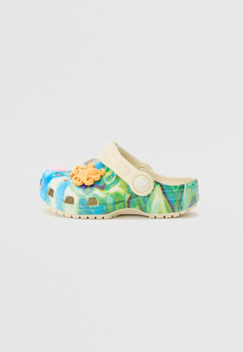 Sabot enfant à enfiler avec motif tie-dye bleu, vert et jaune, bride beige et décoration pieuvre orange sur le dessus.