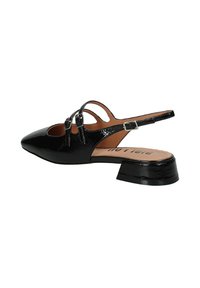 Scarpa slingback in vernice nera con punta affusolata, dettagli con doppia fibbia e tacco basso a blocco. Presenta un design con ritagli aperti laterali.
