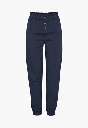 Marineblå tapered bukser med elastisk talje og tre træknapper foran. Manchetter ved anklerne med en glat tekstur.