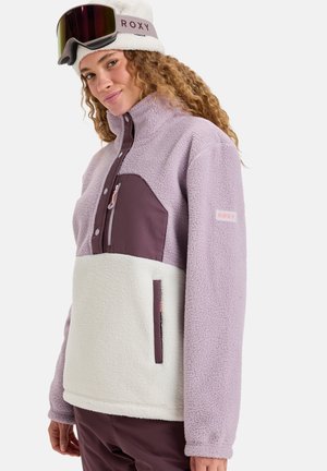 Fleece pullover in lavendel en crème met een ritszak op de borst, hoge kraag en Roxy-logo op de mouw. Zachte, textuurlijke stof.