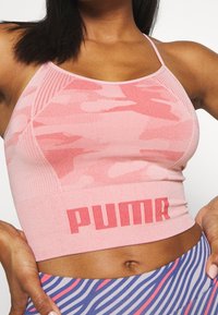 Rosa atletisk crop top med camouflage mønster, ribbet talje og branding i fed skrifttype. Letvægts, tætsiddende design med spaghetti-stropper.