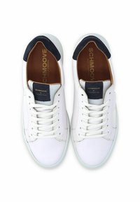 Baskets blanches en cuir avec des accents en daim bleu marine au niveau du talon. Présente une languette en maille texturée et des lacets plats. Design lisse et minimaliste.