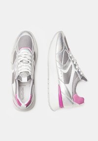 Baskets argentées avec des détails en maille et en vernis, présentant des accents roses sur le talon, une semelle blanche et des lacets plats.