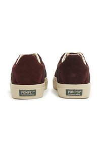 Maroonske nubuk tenisice s bež gumenom podlogom, s logom na peti i krem podstavom. Niske, zaobljene forme.