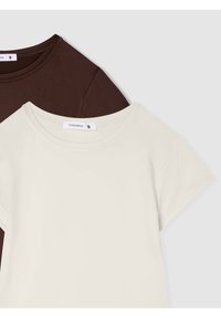 Dwie koszulki: jedna w ciemnym brązie, druga w kolorze ecru. Obie mają krótkie rękawy, okrągły dekolt i są wykonane z miękkiego materiału. Widoczna metka marki.