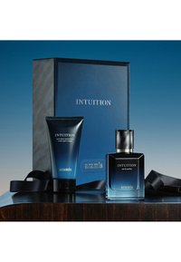 Intuition gavekasse med en mørkeblå boks, en Eau de Parfum-flaske med sølvdetaljer og en fugtgivende creme i matchende farve og branding.