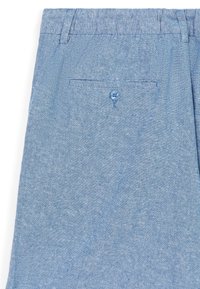 Helle blaue Stoffhosen mit strukturiertem Finish, ausgestattet mit einer Gesäßtasche mit einem einzelnen blauen Knopfverschluss. Schlichtes, lässiges Design.