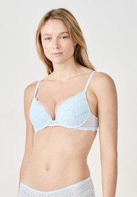 Soutien-gorge en dentelle bleu clair avec des bonnets triangulaires, des bordures décoratives et des fines bretelles. Texture transparente avec des motifs brodés.