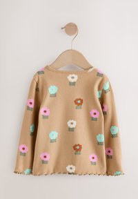 Langærmet beige top med ribbet tekstur, dekoreret med farverige blomster i pink, blå og brun, med en bølget kant.