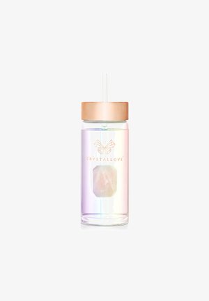 Przezroczysty plastikowy kubek z gradientowym, irydyscencyjnym wykończeniem, różowo-złotą przykrywką oraz widocznym akcentem w postaci kryształu u podstawy. Słomka w zestawie.