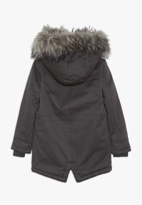 Ciemnoszara parka z kapturem wyłożonym futrem, posiadająca zapinany na zamek przód oraz boczne kieszenie. Materiał jest gładki o lekko połyskującej powierzchni.