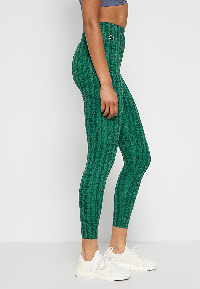 Leggings verdi con un motivo geometrico, vita alta e un accento con logo. Realizzati in materiale elasticizzato, progettati per il comfort e il movimento.