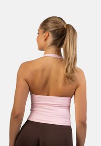 Dopasowany top w stylu halter w miękkim różowym materiale, z gładką fakturą i marszczonym wzorem, połączony z brązowymi, wysokimi majtkami.