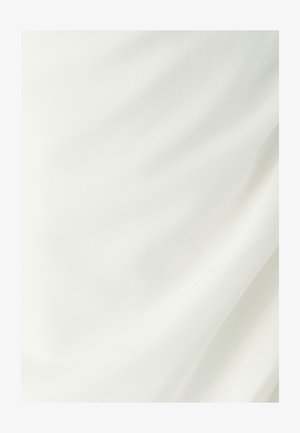Sile ja valge kangas pehmete kortsudega ja õrnade varjudega, rõhutades selle tekstuuri ja kerget langevust.