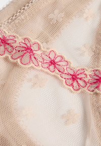 Beige kantstof met een delicate bloempatroon, versierd met roze geborduurde bloemen langs de rand, met een zachte, gestructureerde oppervlakte.