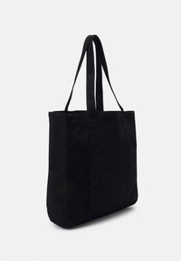 Svart tote-väska tillverkad av slitstarkt tyg med två långa handtag, rektangulär form och minimala sömnadsdetaljer. Slät yta, inga mönster.