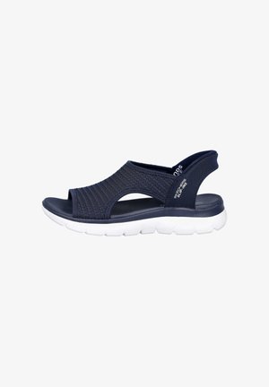 Sandalia azul marino de punta abierta con parte superior de tela tejida, suela acolchada blanca y correa trasera, con la marca "Skechers Slippers" en el lateral.