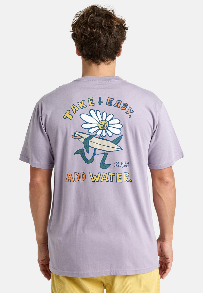 Lila bomullströja med ett stort grafiskt tryck av en blomma med ansikte som håller i en surfbräda. Texten lyder "TAKE IT EASY. ADD WATER."