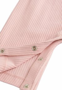 Jasnoróżowa, prążkowana tkanina z napami na dolnej krawędzi. Tekstura jest miękka, a design zawiera subtelne pionowe paski.