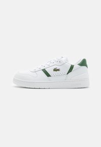 White leather sneakers with green accents, perforated detailing, and a logo on the side. Features a textured sole and a padded collar.