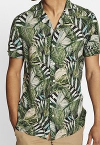 Kortærmet skjorte med knapper, prydet med et mønster af grønne og sorte tropiske blade med hvide striber, lavet af let stof.