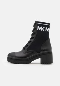Bottines noires avec un col en textile haut ressemblant à une chaussette, un devant à lacets, un bout rond, un talon épais et un détail de logo sur le côté.