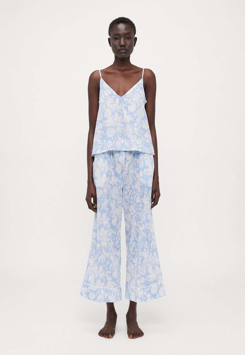Conjunto de duas peças azul claro com padrões florais. A parte de cima é uma camisola solta com alças finas e calças de perna larga com um design fluido.