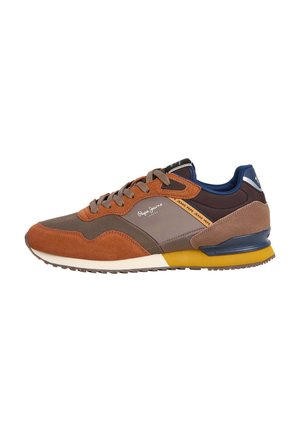 Men's sneaker featuring a blend of brown suede and mesh materials, a cushioned navy blue heel, and yellow rubber accents on the sole.