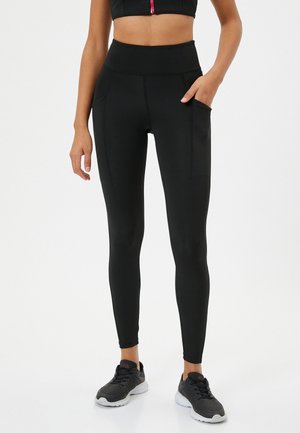 Zwarte high-waisted legging gemaakt van rekbaar materiaal, met twee zijzakken, een gladde textuur en een aansluitend ontwerp.
